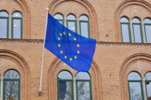a european flag flying in front of a brick building
